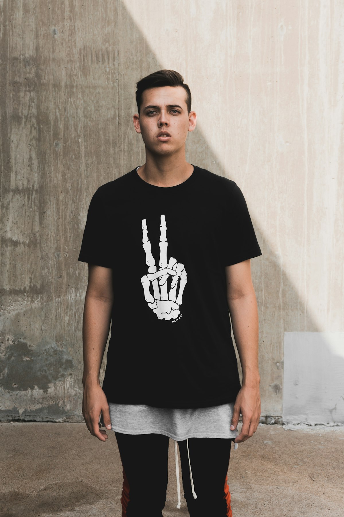 A black t-shirt with a white graphic worn by a model.