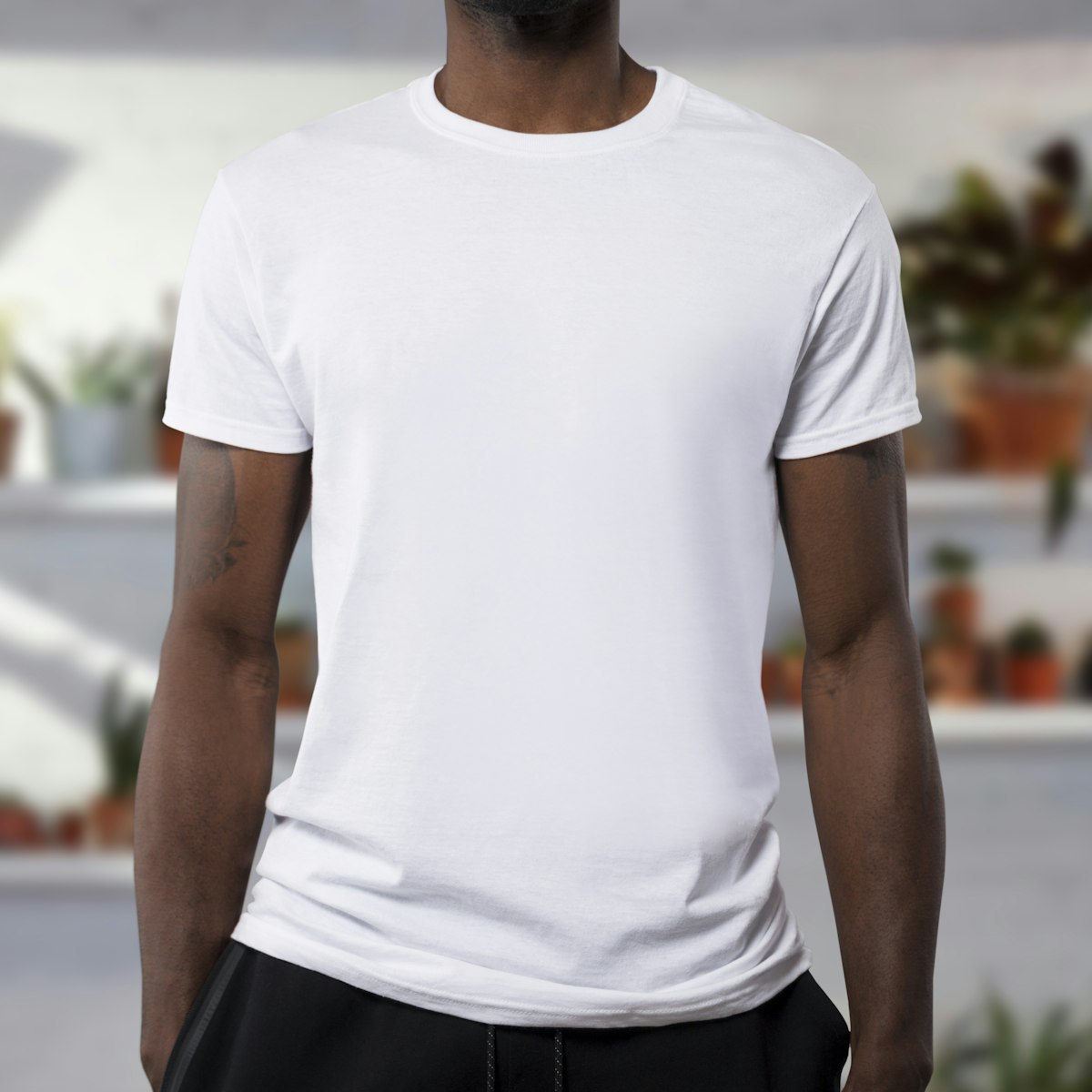 A plain white t-shirt on a model against a neutral background.